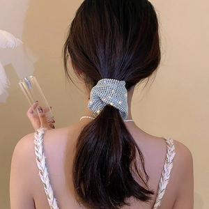 Detail view of a sparkling rhinestone scrunchie on a ponytail with high-shine crystals