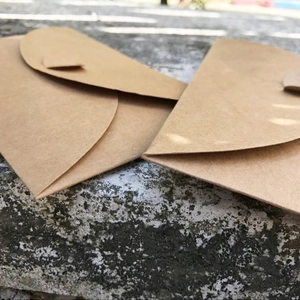 Two premium 300g vintage brown kraft paper envelopes on a natural stone surface