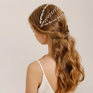 Detailed view of Baroque bridal headband with gold leaves and white pearls on a model