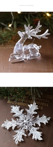 Macro detail of acrylic reindeer and snowflake ornaments with silver glitter accents