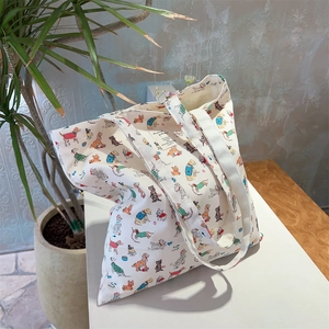 Detail view of cotton tote bag showing multiple cartoon dog patterns on white fabric