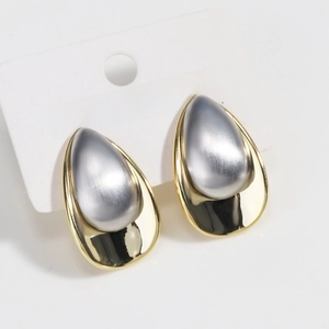 Detail of two-tone gold and silver waterdrop earrings with a brushed metal texture