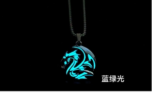 Macro detail of dragon totem pendant featuring luminous blue-green glow in the dark