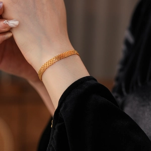 Détail du bracelet en maille plaqué or 18 carats sur mannequin avec texture