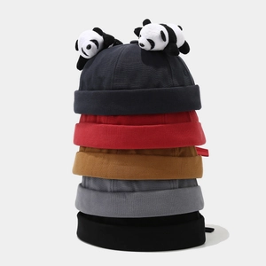 Detailed view of miki hats in five colors stacked with cute panda bear decorations