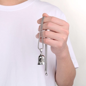 Close-up of vintage steel guardian bell pendant with Masonic symbol held by a model