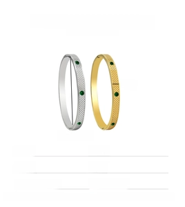 Detail showing 6mm width and dimensions of gold and silver steel bangles with green gems