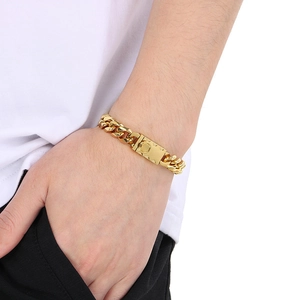 Detail shot of a 10mm golden Miami Cuban link bracelet worn by a model in casual style