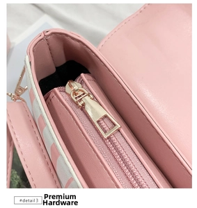 Close-up of premium light gold metal zipper and pink striped leather on handbag