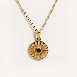 Macro shot of evil eye pendant with pink enamel and gold-plated chain detail
