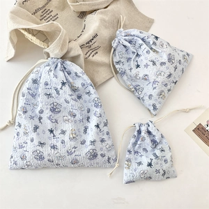 Close-up of three sizes blue drawstring organizers with embossed sea life patterns