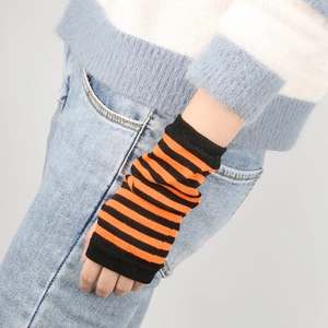 Detail of black and orange striped knit fingerless gloves showing the textured fabric