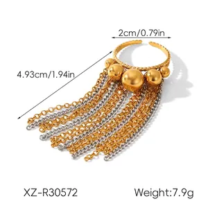 Detail showing two-tone gold and silver tassel ring with polished metal beads and chain