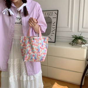 Dettaglio della borsa in tela floreale con manici rosa e motivi di tulipani in stile vita