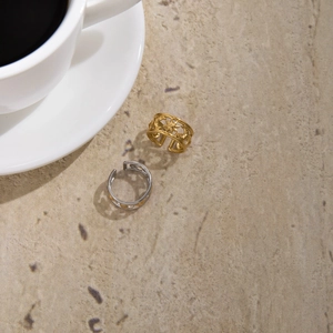 Detail view of 18K gold and silver celestial star and moon cutout open rings on stone