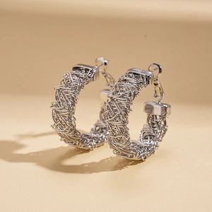 Detail of silver woven mesh texture on geometric creased metal hoop earrings