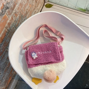 Close-up of pink and white plush crossbody bag showing embroidery and fuzzy texture