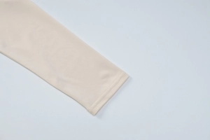 Gros plan détaillé du poignet en maille beige montrant des coutures propres et régulières