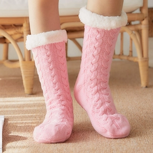 Pink cable knit winter slipper socks with plush lining and white fleece cuff for indoor warmth