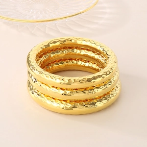 Detail of three-piece set of 18k gold plated stainless steel hammered texture bangles