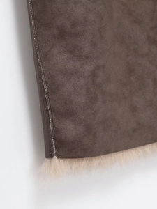 Détails du manteau en simili cuir marron foncé avec coutures et doublure en fourrure