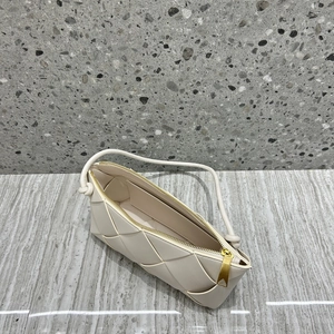 Overhead view of off-white woven leather bag with fine shoulder strap and gold zipper