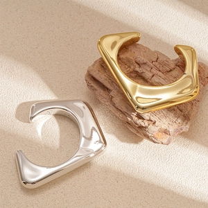 Minimalist gold and silver irregular geometric C-shaped open bangles with mirror finish