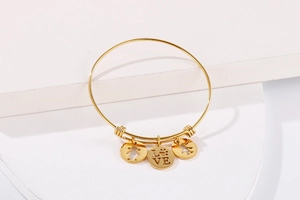 Detail view of gold adjustable bracelet with silhouette girl, boy, and love charms