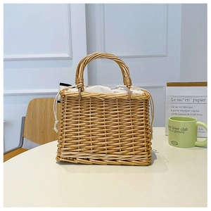 Detail of handmade wicker basket bag with cream fabric drawstring liner on white desk