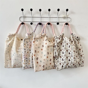 Macro detail of textured canvas tote bags featuring cute cartoon prints and woven handles