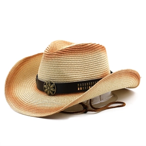 Detail of straw cowboy hat with leather band, metal flower emblem and wind rope