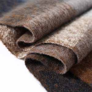 Detailed texture of autumn plaid cashmere-like scarf in brown, navy and grey tones
