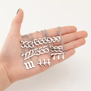 Hand holding various silver stainless steel necklaces with gothic angel number pendants