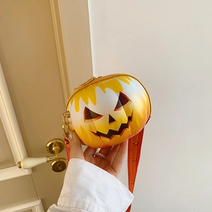 Detail view of round Halloween pumpkin crossbody bag with bright orange gradient and smile face