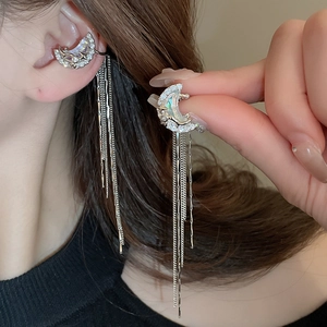 Detailed close-up of sparkling moon and star tassel earrings with iridescent main stone