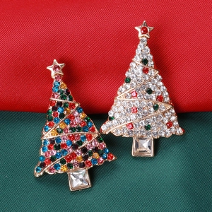 Close-up of colorful rhinestone Christmas tree brooches on festive red and green fabric