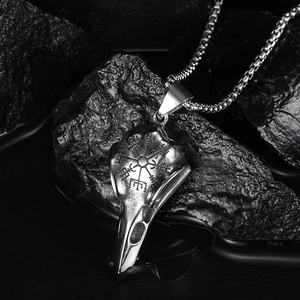 Nordic Viking raven skull stainless steel necklace with engraved runes on a dark rock