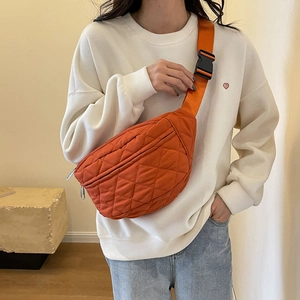 Orange quilted nylon crossbody chest bag with adjustable strap and buckle on model
