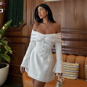 Detail of off-shoulder white mini dress featuring decorative buttons and split cuffs