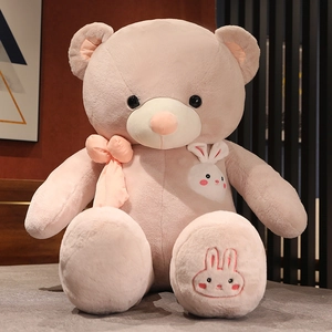 Macro detail of plush teddy bear with pink bow tie and cute rabbit embroidery decoration