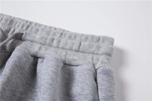 Vue détaillée de la taille élastique et du cordon sur ce pantalon de sport gris
