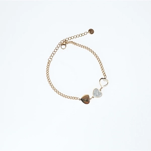 Golden titanium steel heart bracelet with sparkling zircon stones on a white background