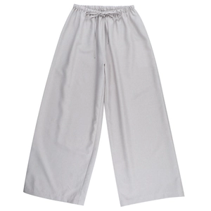 Dettaglio dei pantaloni larghi in lino grigio con vita elastica a coulisse e vestibilità