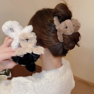 Close-up of plush faux fur hair claw clips in neutral colors with woven twist design
