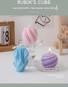 Detailed view of spiral geometric candles in pink, blue and purple on glass holders