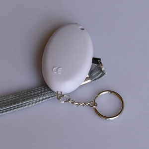 Detail view of white personal safety alarm with CE certification and durable grey lanyard