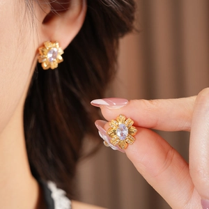 Vue macro de boucles d'oreilles fleur vintage en or avec pierre mauve et zircons