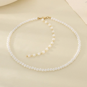 Dettaglio di collana di perle con chiusura in metallo dorato e catena di estensione