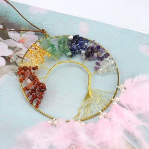 Detailed view of Tree of Life dream catcher featuring colorful crystals and pink feathers