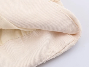 Close-up of premium cream twill fabric showing detailed stitching on the casual jacket